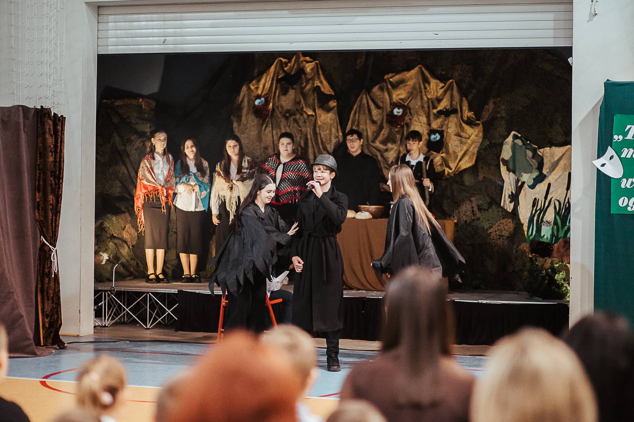 Grupa uczniów bierze udział w akademii z okazji Święta Patrona