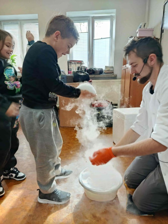 Uczeń stoi w kolejce, czekając, aż laborant zaprezentuje efekt doświadczenia chemicznego, zdjęcie 3 z 5