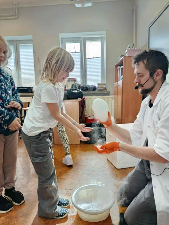 Uczennica czeka w kolejce do laboranta, który pokazuje efekt eksperymentu, zdjęcie 4 z 5