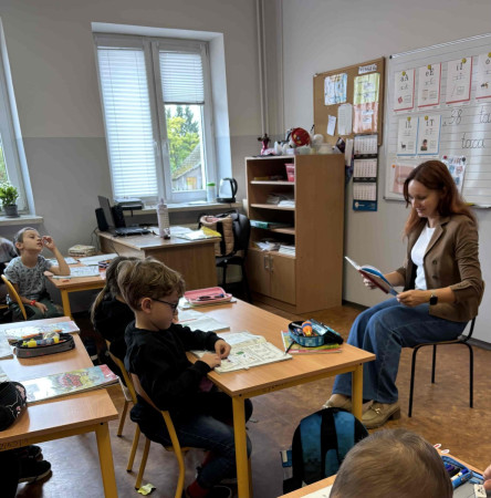 Zajęcia w szkole – nauczyciel głośno czyta uczniom książkę w ramach Ogólnopolskiego Dnia Głośnego Czytania, zdjęcie 3 z 5