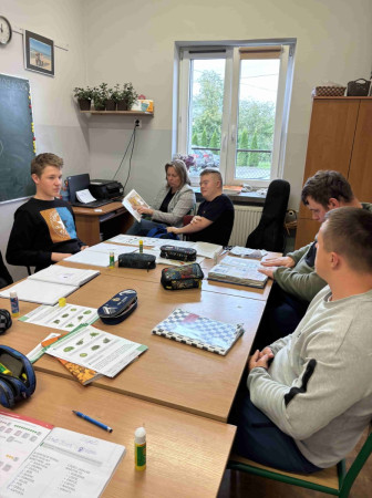 Klasa szkolna podczas lekcji, nauczyciel czyta na głos fragment utworu w ramach Ogólnopolskiego Dnia Głośnego Czytania, zdjęcie 4 z 5