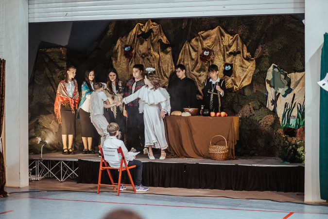 Scena Dziadów z udziałem uczniów w epokowych strojach, osadzona na bogato udekorowanej scenie, zdjęcie 4 z 10