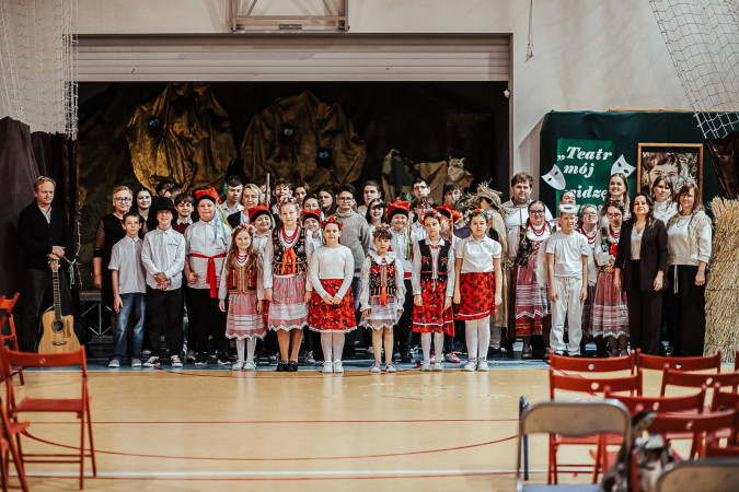 Uczniowie w kostiumach i nauczyciele pozują wspólnie po zakończonym występie, zdjęcie 10 z 10