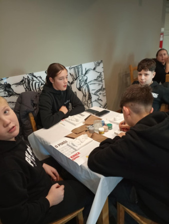 Grupa dzieci pracuje nad dekorowaniem gipsowych figurek olkuskich gwarków, zdjęcie 4 z 5