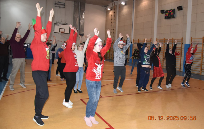 Seniorzy i uczniowie biorą udział w integracyjnych tańcach mikołajkowych, zdjęcie 4 z 5