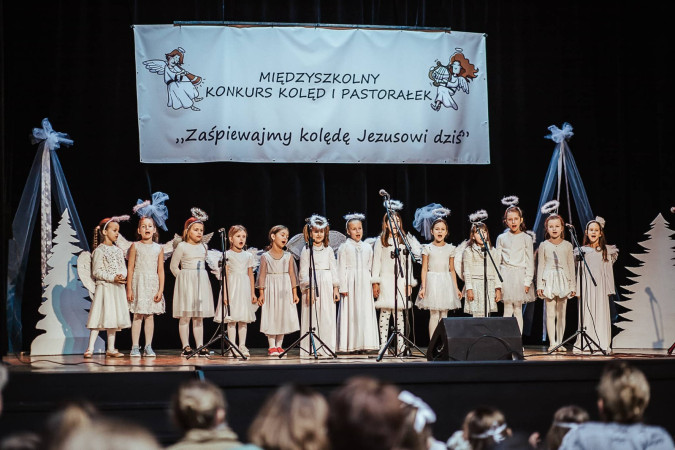 Występ dzieci w strojach aniołków podczas Międzyszkolnego Konkursu Kolęd i Pastorałek, zdjęcie 3 z 5