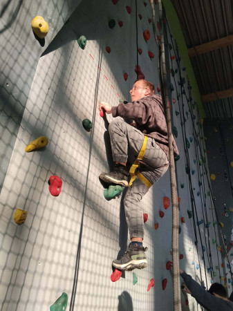 Uczeń w trakcie wchodzenia na ściankę wspinaczkową, zdjęcie 2 z 5
