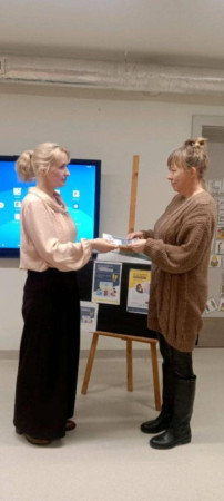 Nauczyciel wręcza rodzicowi ulotki informacyjne, zdjęcie 2 z 3