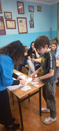 Nauczyciel rozdający uczniom karty pracy – zdjęcie 3 z 5