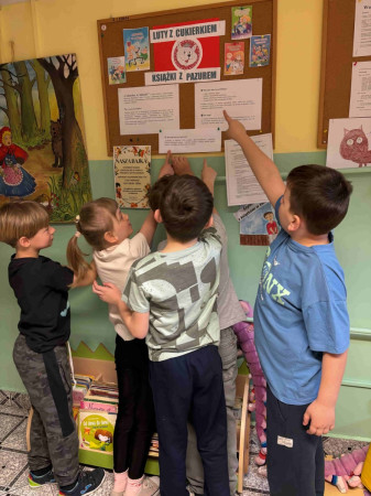 Uczniowie wskazują gazetkę szkolną akcji w bibliotece – zdjęcie 5 z 5