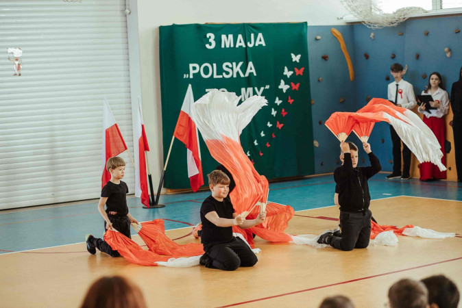 Dzieci z flagami wiwatują podczas występu, zdjęcie 4 z 5
