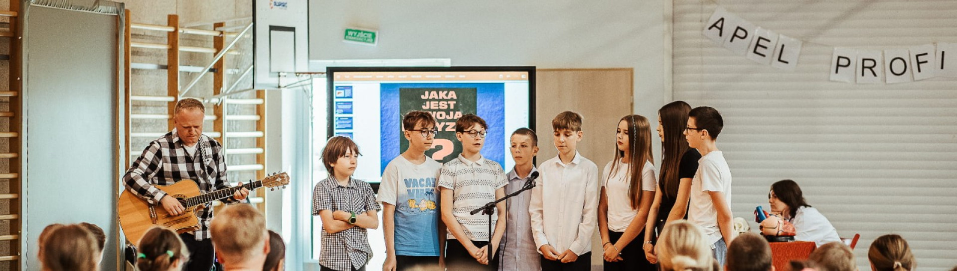 Link otwiera się w nowym oknie przeglądarki Uczniowie z nauczycielem wykonują utwór 'Tolerancja' podczas zakończenia apelu profilaktycznego
