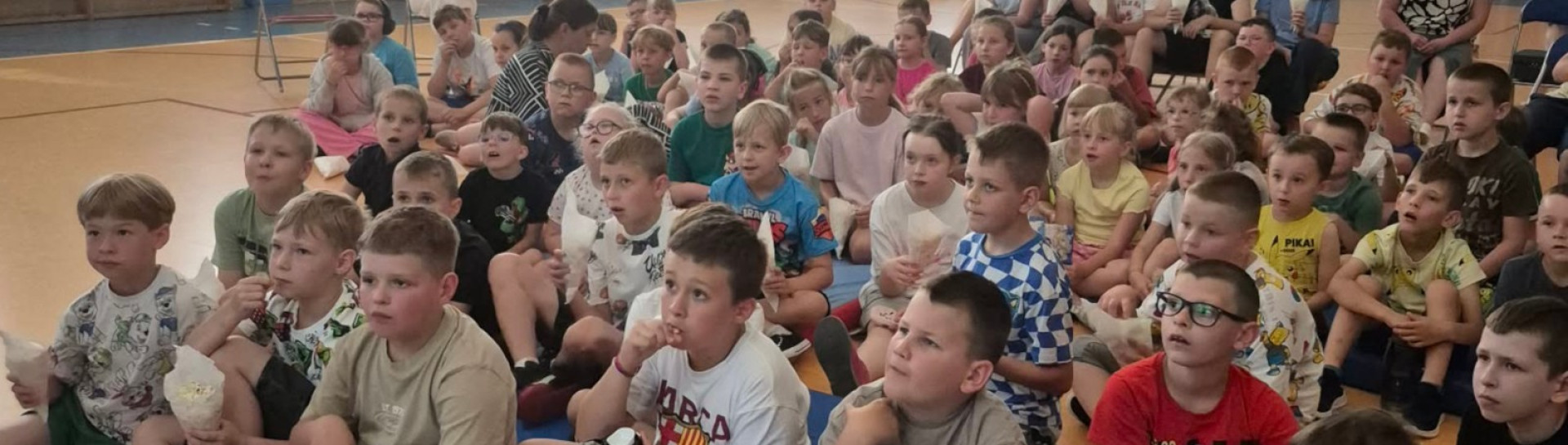 Link otwiera się w nowym oknie przeglądarki Uczniowie oglądają bajkę na sali gimnastycznej