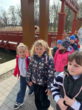 Dzieci spacerują po parku miejskim w Miechowie, ciesząc się wiosenną pogodą, zdjęcie 2 z 4